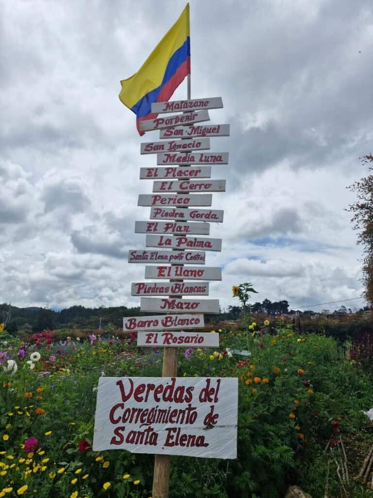 1. Letrero con nombres de lugares en Santa Elena, con bandera de Colombia al fondo.